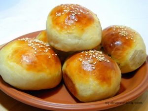 pãozinho recheado em cima de um prato de barro